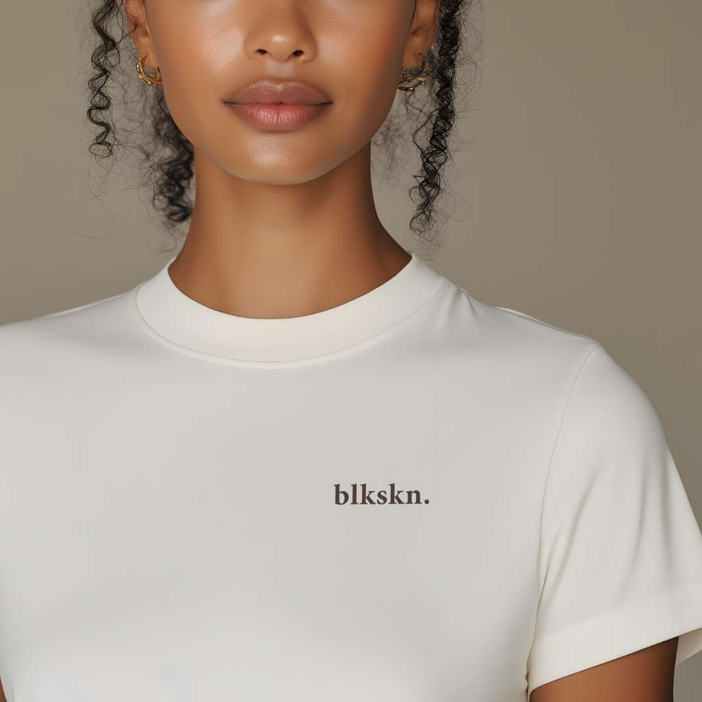 Person wearing a white t-shirt with 'blkskn.' branding against a neutral background