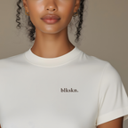Person wearing a white t-shirt with 'blkskn.' branding against a neutral background
