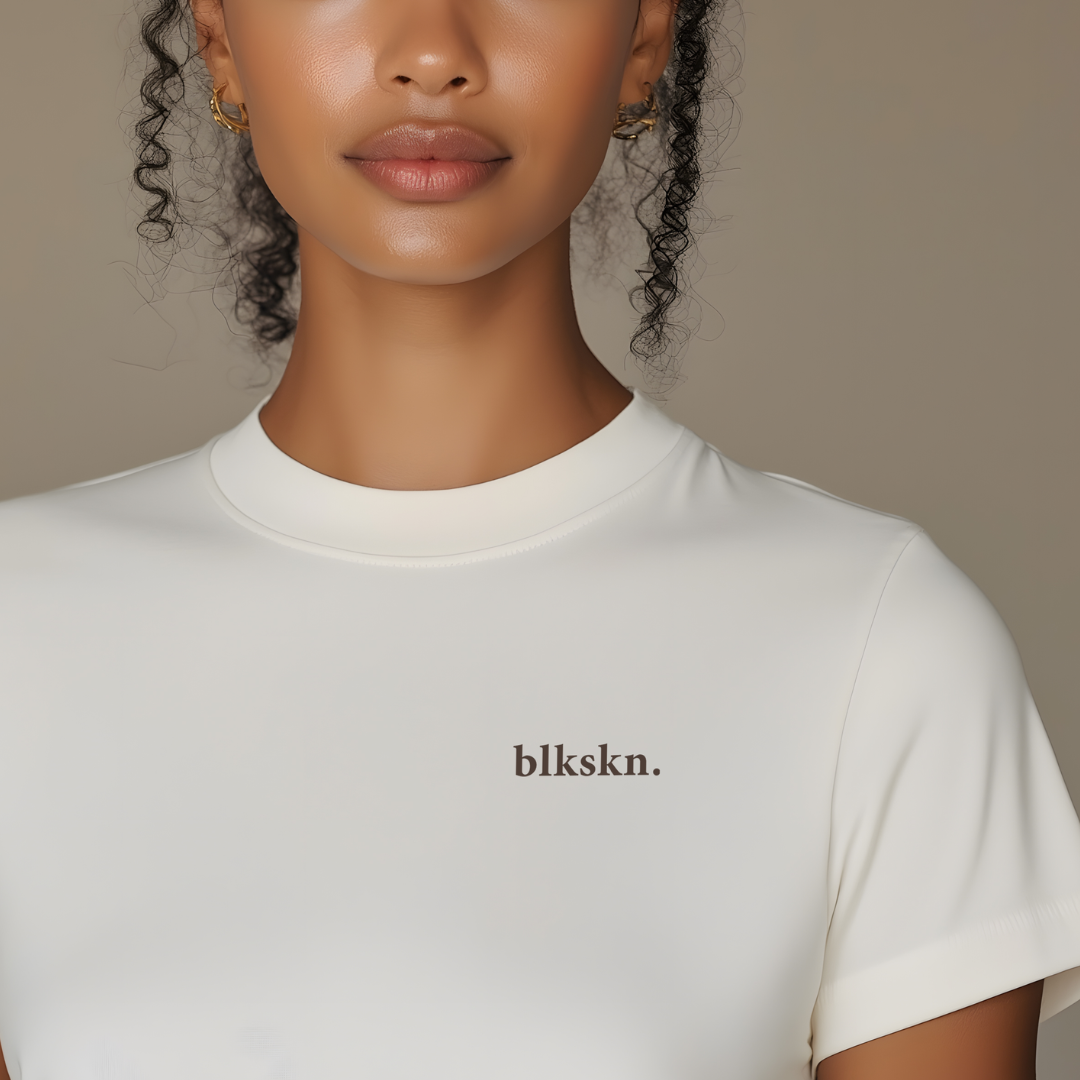 Person wearing a white t-shirt with 'blkskn.' branding against a neutral background
