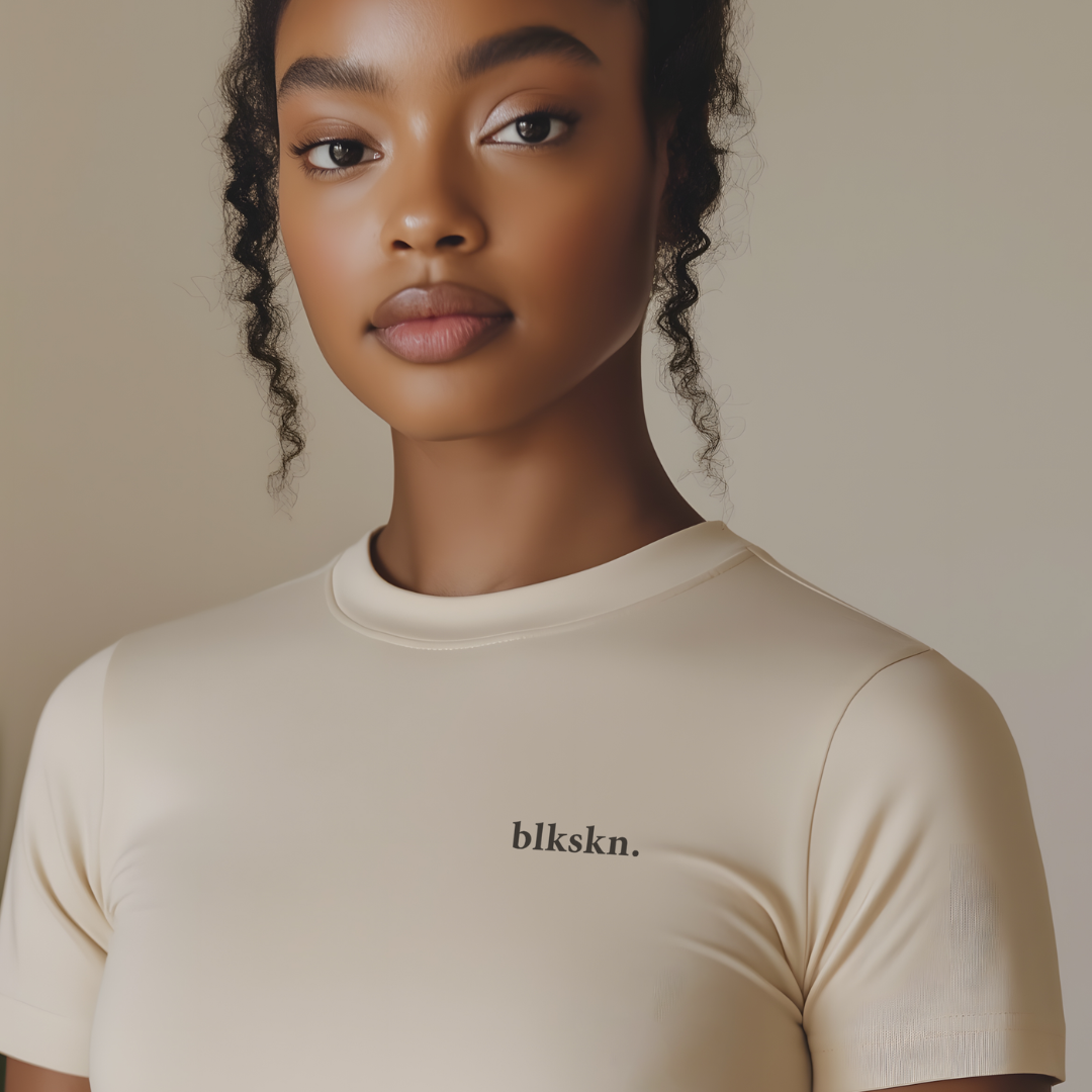 Person wearing a beige t-shirt with 'blkskn.' logo against a neutral background